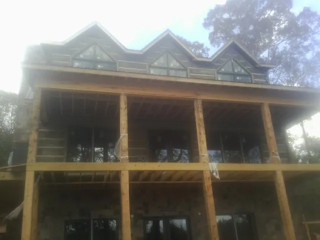 Dormers and porch framing on a large log home under construction — Roof Coating work by our crew in Scott Depot